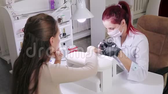 在美容院带手套的女美甲师在涂胶前先给顾客做一个硬件美甲视频的预览图