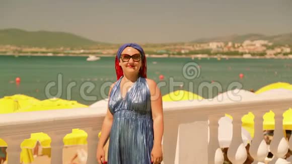 一个戴着眼镜的小辫子的年轻女子站在海滨长廊上视频的预览图