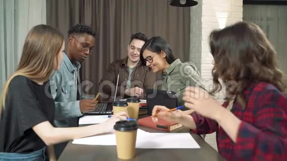 一群多民族的学生或同事在咖啡馆或办公室里谈笑风生视频的预览图