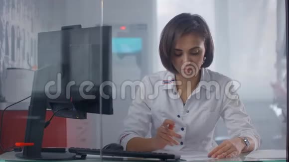 女医生坐在医院的桌子旁用手提电脑打字女医生护士视频的预览图