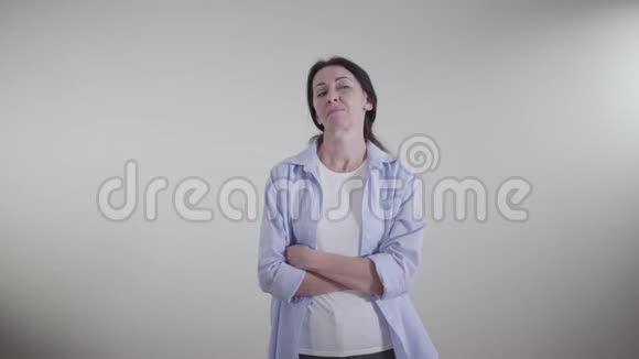 一幅成年骄傲的白种人女人带着讽刺的微笑向外看的肖像站在白色背景上的反讽女士视频的预览图