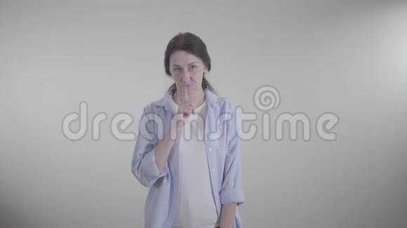 中镜头的成年白种人女人做嘘手势和看镜头一位严肃的黑发女士摆着白色视频的预览图