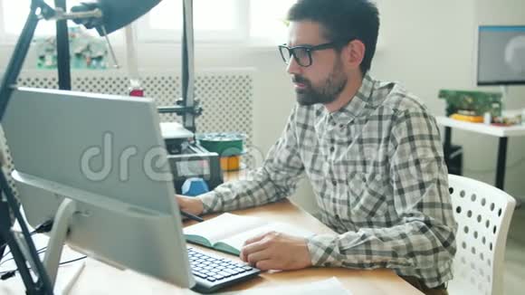年轻人使用电脑和制作3D打印机元件的慢动作视频的预览图