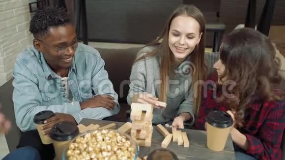 一群快乐的朋友在客厅里玩积木移除游戏给五个视频的预览图