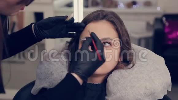 专业的眉毛大师在美容院用刷子给客户画眉毛视频的预览图