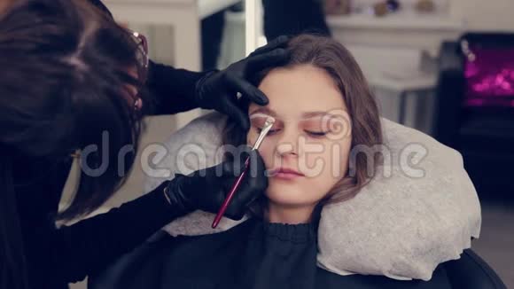 在一家美容院专业的眉毛师女士给客户画眉毛视频的预览图