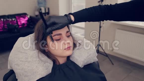 在一家美容院专业的眉毛师女士给客户画眉毛视频的预览图