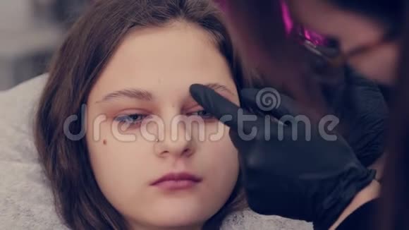 专业的眉师用镊子给美容院的客户拔眉毛视频的预览图