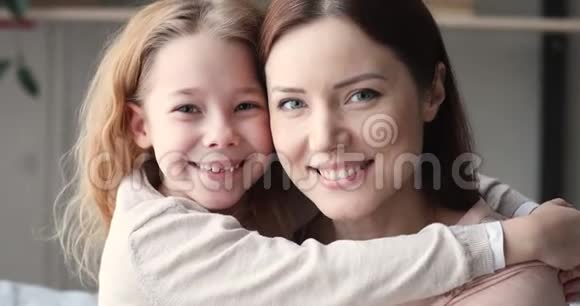 可爱的女儿和妈妈拥抱着看着相机肖像视频的预览图