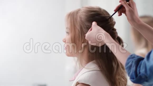 美发师用梳子整理发型卷辫4K红色相机拍摄视频的预览图