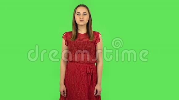 穿着红色裙子的温柔女孩兴奋地看着镜头然后庆祝她的胜利绿色屏幕视频的预览图