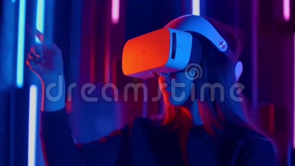 站着的女士尝试着用霓虹灯做VR耳机视频的预览图