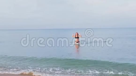 一个穿着黑色泳衣的女人从海上上岸视频的预览图