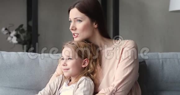 梦中的单身妈妈拥抱可爱的女儿在沙发上放松视频的预览图