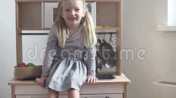 小女孩坐在玩具厨房里笑着视频的预览图