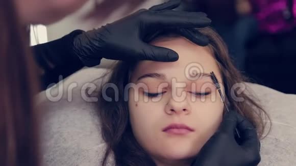 专业大师眉毛女士在美容院给客户梳眉毛视频的预览图