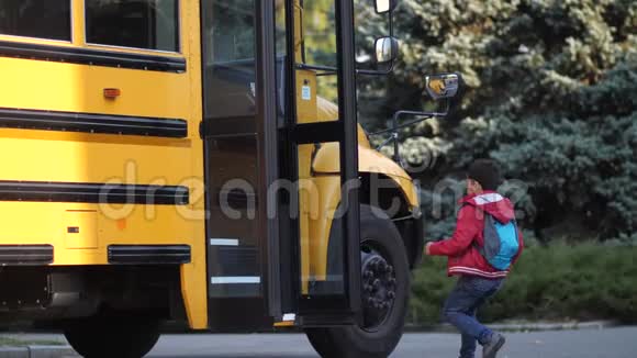 不同的快乐的学生匆忙地进入校车视频的预览图