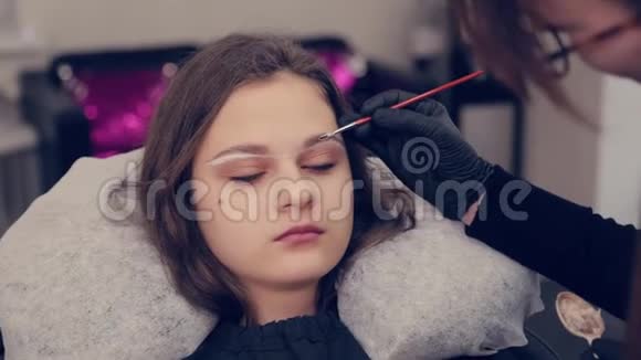 专业的眉毛大师在美容院用刷子给客户画眉毛视频的预览图