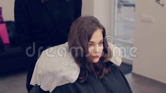 化妆师女士躺在美容院的客户椅子上视频的预览图