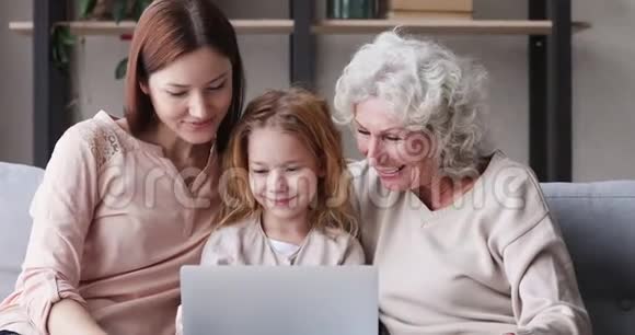 三代女性家庭笑着看笔记本电脑上的搞笑视频视频的预览图