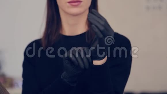 化妆师女士在美容院的手术前戴上橡胶手套视频的预览图