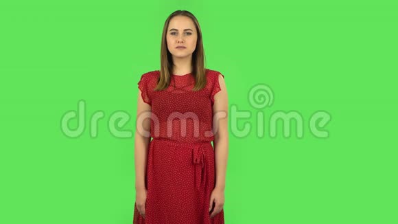 穿着红色裙子的温柔女孩正满怀期待地等待着绿色屏幕视频的预览图