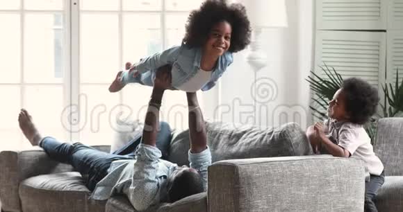 快乐的美国父亲和孩子们在客厅里玩耍视频的预览图