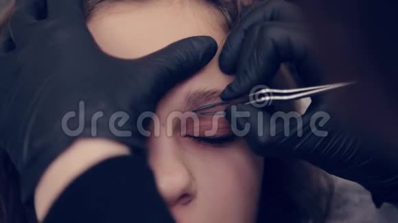 专业的眉师用镊子给美容院的客户拔眉毛视频的预览图