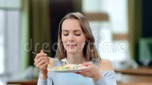 饥饿的女人吃新鲜沙拉的肖像盘子用叉子中型近距离拍摄4k红色相机视频的预览图