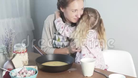 小女儿在餐桌旁轻轻地拥抱母亲视频的预览图