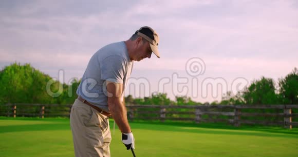 英俊的老高尔夫球手摇摆高尔夫俱乐部在天堂高尔夫视频的预览图