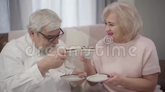 特写白种人老男女在家喝茶快乐成熟的配偶一起度过一个晚上视频的预览图