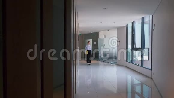 年轻漂亮的商务女性穿着穿过走廊视频的预览图