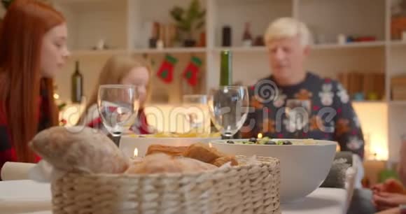 一家人坐在餐桌前圣诞爷爷孙女的头头一个红发女孩视频的预览图