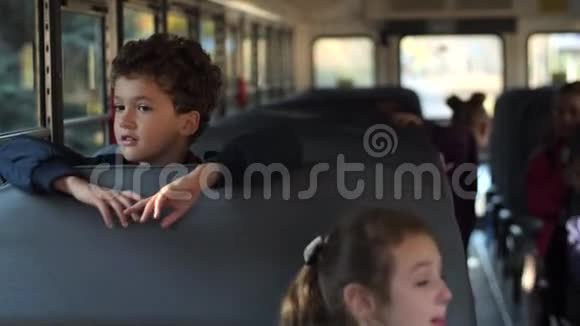 卷毛的小学生乘校车回家的肖像视频的预览图
