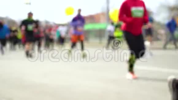 在柏油路上参加城市马拉松比赛的五颜六色的人群视频的预览图
