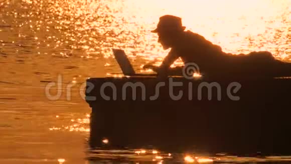 希普斯特带着笔记本上的海上日落字体程序员在风景如画的海滩上写代码成功的旅行博客视频的预览图