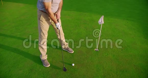 年轻英俊的高尔夫球手日落时在美丽的球场上挥杆击球视频的预览图