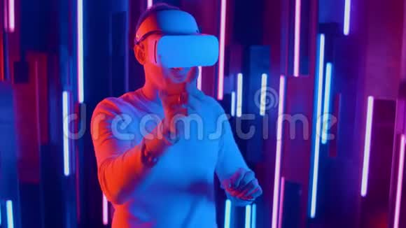 男子佩戴VR耳机快速斜坡从一边到另一边同时在黑暗的空间播放照明霓虹灯视频的预览图