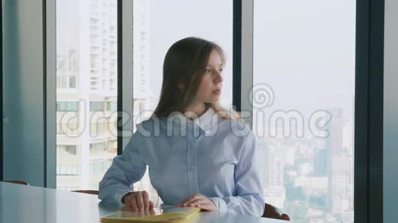带文件夹的女商人办公桌上有文件靠近窗户可以看到城市景色视频的预览图
