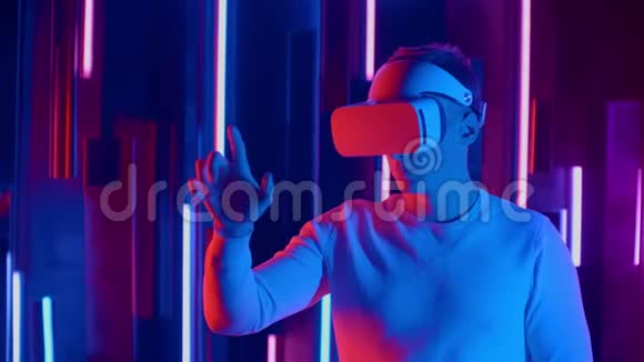 无脸男子戴VR耳机在黑暗空间与霓虹灯用户头转向一边看虚拟视频的预览图
