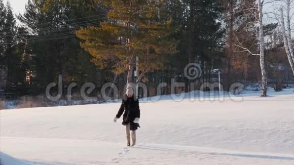 冬林雪上奔跑欢乐的年轻女子视频的预览图