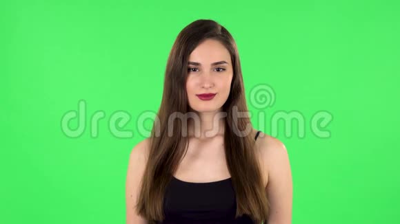 女人站着微笑着散开看着镜头绿色屏幕视频的预览图