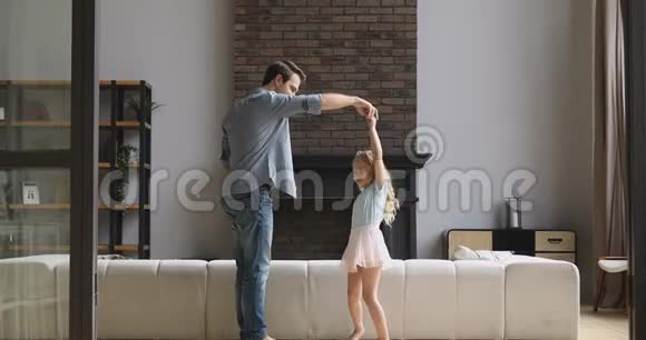 英俊的年轻父亲扭着小公主女儿吻着手视频的预览图