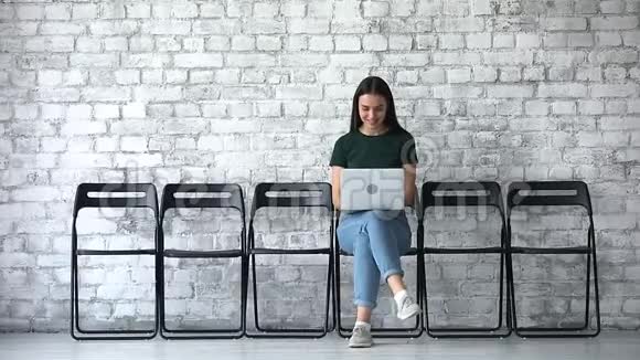 微笑女性求职者使用笔记本电脑等待面试视频的预览图