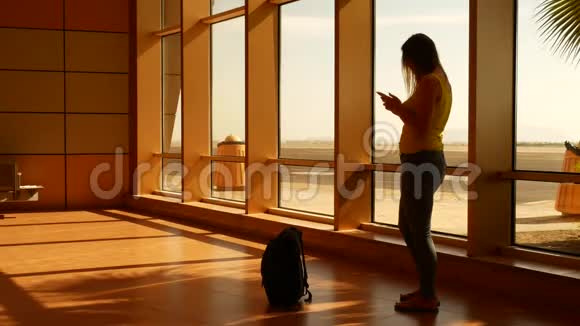 女游客在机场使用智能手机视频的预览图