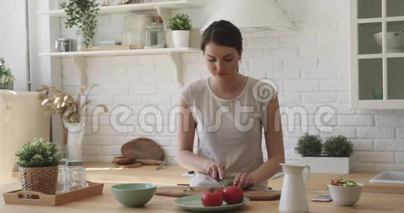 可爱的年轻女子独自在家做饭视频的预览图