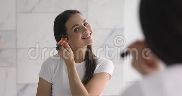 微笑年轻迷人的女人照镜子用刷子视频的预览图