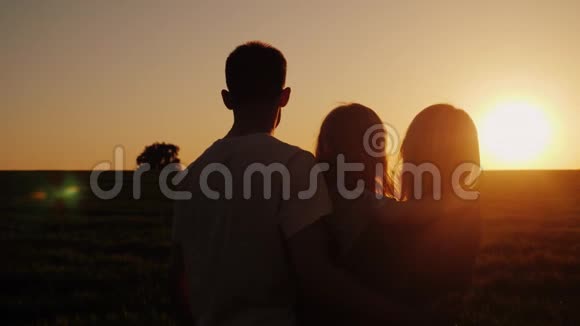 一家人带着孩子看着美丽的日落视频的预览图