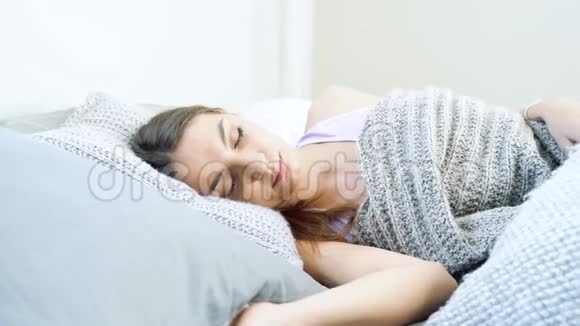 年轻的愤怒的女人试图躺在床上睡觉愤怒的女孩用枕头遮住耳朵噪音很大视频的预览图